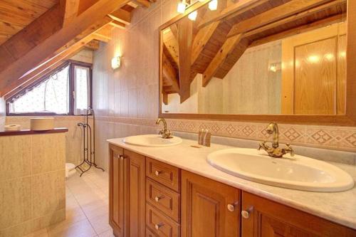 baño con 2 lavabos y espejo grande en Arroquets, en Vielha