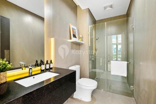 a bathroom with a toilet and a glass shower at DapenBI ApartHotel by Kozystay - Tebet in Jakarta