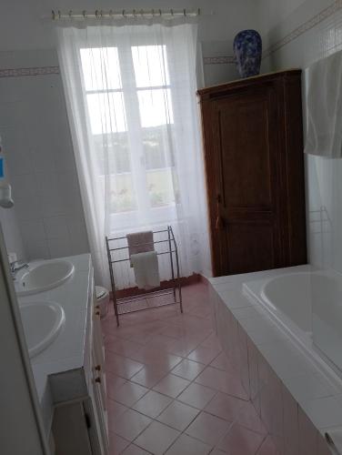 une salle de bain avec un lavabo, une baignoire et des toilettes dans l'établissement Manoir La Breuille, à Montmoreau