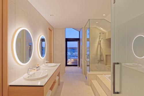 a bathroom with two sinks and a shower and two mirrors at TOKIWA M-GARDEN in Mito