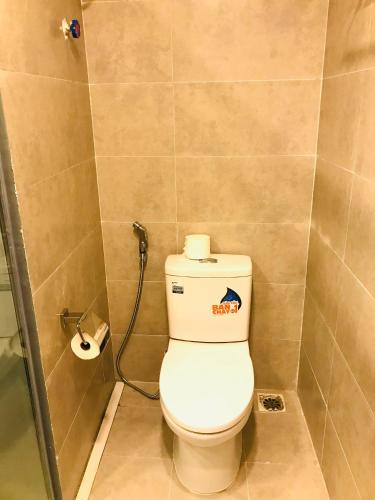 a bathroom with a toilet with a roll of toilet paper at Unique Serviced Apartment in Hanoi