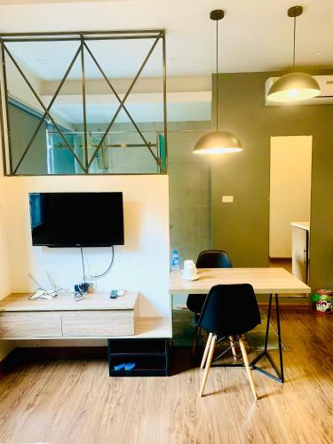 a room with a desk with a tv and a table at Unique Serviced Apartment in Hanoi