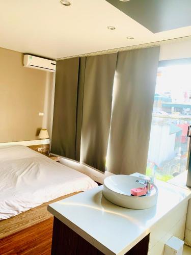 a bedroom with a bed and a white table with a clock at Unique Serviced Apartment in Hanoi