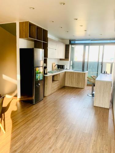 a kitchen with a black refrigerator and wooden floors at Unique Serviced Apartment in Hanoi