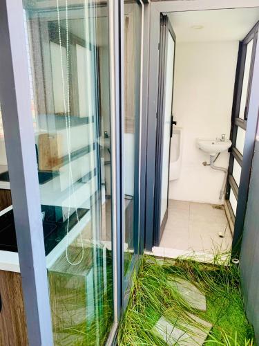a bathroom with a glass door and a toilet at Unique Serviced Apartment in Hanoi