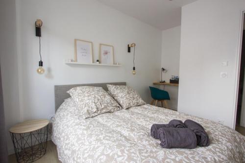 Un dormitorio con una cama con un montón de ropa. en L'olivier - Appartement moderne et chaleureux - TRAM et PARC, en Grenoble