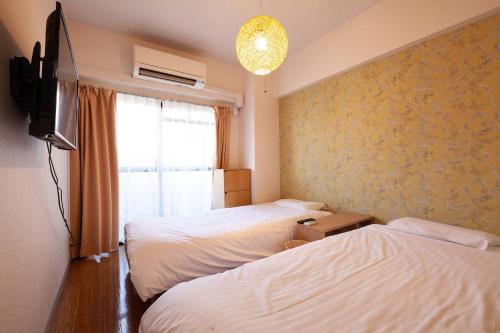 Habitación con 2 camas, TV y ventana. en Chatelet Nishi-Oi, en Tokio