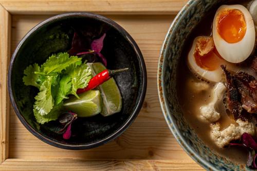 two bowls of soup and an egg on a table at REED Boutique HOTEL & BISTRO in Siófok