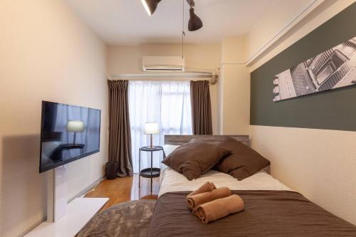 Un dormitorio con una cama y un televisor de pantalla plana. en Chatelet Nishi-Oi, en Tokio