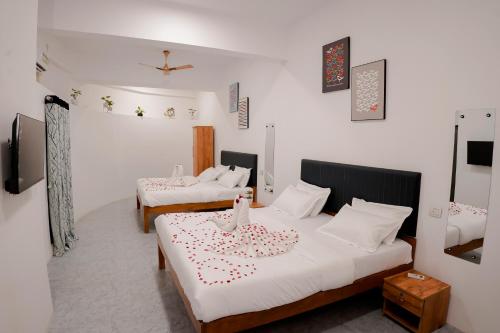een kamer met 2 bedden en een tv. bij Hotel Royal Accord in Surat