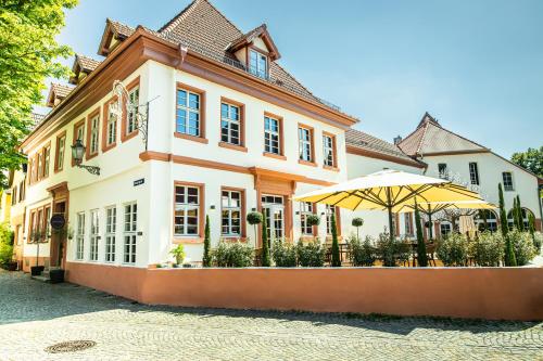 un bâtiment avec un parasol devant lui dans l'établissement The Boutique Hotel Dsignio, à Ladenburg