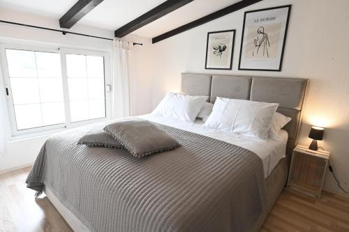 1 dormitorio blanco con 1 cama grande con almohadas blancas en Apartment Kokolo sea view Hvar, en Hvar