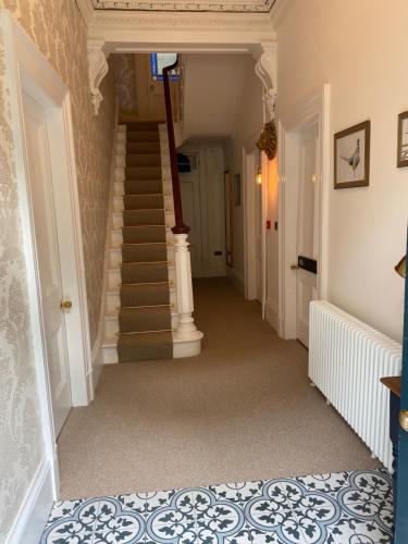 a hallway with a stairway with a spiral staircase at Heathbank House B&B in Matlock Bank