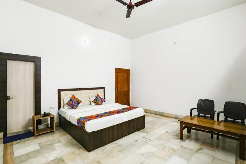 1 dormitorio con 1 cama, mesa y sillas en FabExpress Prashansa Palace, en Varanasi