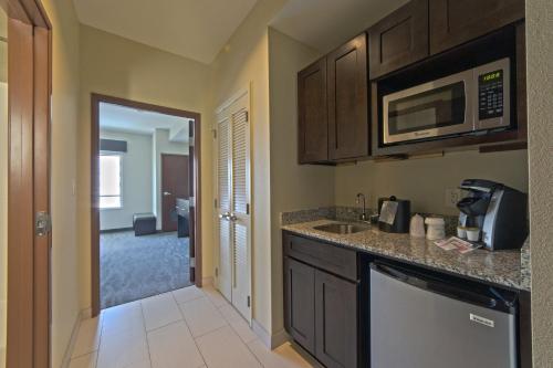 a kitchen with a sink and a microwave at Holiday Inn Hotel & Suites Northwest San Antonio by IHG in San Antonio