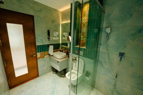 a bathroom with a toilet and a glass shower at ANANSA BOUTIQUE HOTEL by The Kannur Club in Kannur