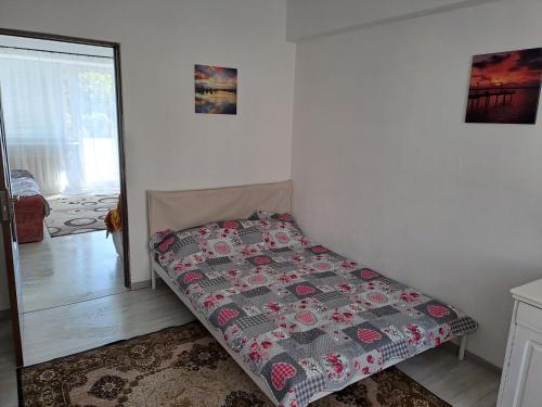 een bed in een kamer met een sprei erop bij Bacău Central in Bacău