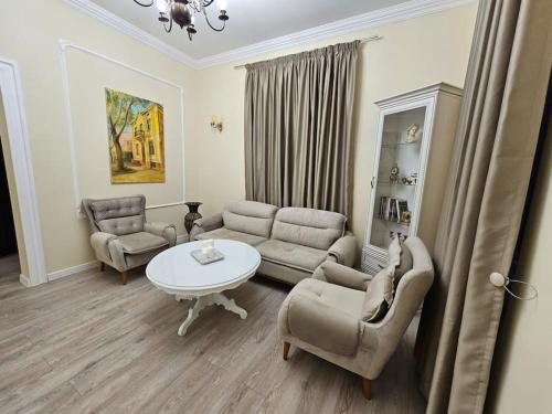 uma sala de estar com um sofá, uma mesa e cadeiras em Iconic House Plovdiv em Plovdiv