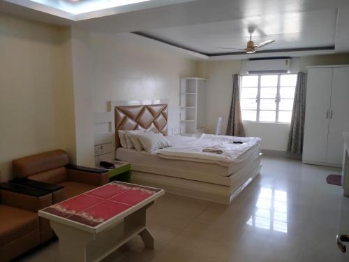 um quarto com uma cama grande e um sofá em HOTEL NL7 em Dimāpur