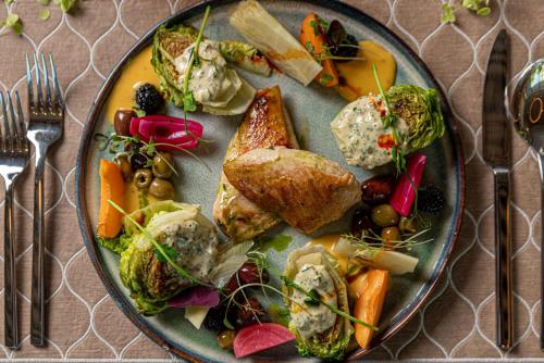 a plate of food with vegetables on a table at REED Boutique HOTEL & BISTRO in Siófok