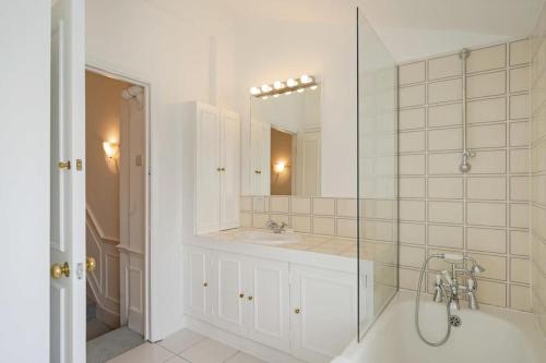 W łazience znajduje się prysznic, umywalka i lustro. w obiekcie Beautiful maisonette in the heart of Chelsea w Londynie