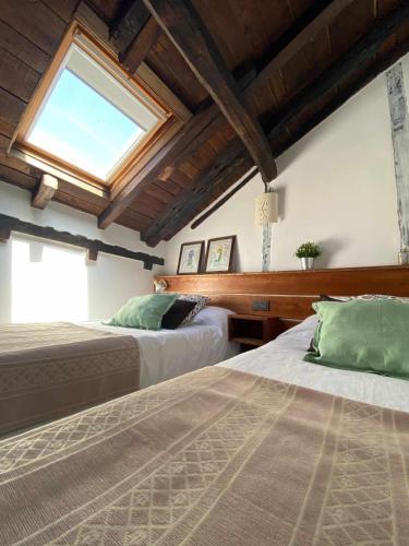 a bedroom with two beds and a window at Las Casas de Quintanilla 3 in Quintanilla las Torres