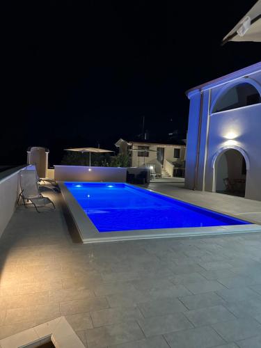 uma piscina com água azul à noite em Villa Blue Paradise - B&B con piscina non lontano da Cagliari em Cagliari