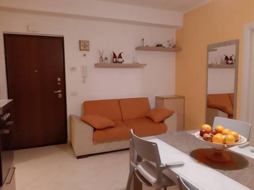 ein Wohnzimmer mit einem Sofa und einem Tisch mit einer Obstschale in der Unterkunft The family nest comodo appartamento nei pressi della stazione centrale in Sulmona