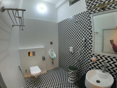 a bathroom with a sink and a toilet and a mirror at Hotel Buddha Park near Sarnath, Varanasi in Varanasi