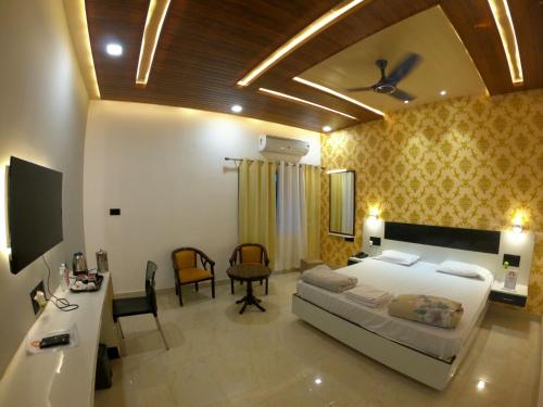 1 dormitorio con 1 cama, mesa y sillas en Hotel Buddha Park near Sarnath, Varanasi, en Varanasi