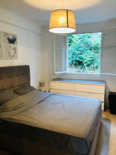une chambre avec un grand lit et une fenêtre dans l'établissement Bel appartement - 50m2 à 7 minutes du centre au calme, à Nice