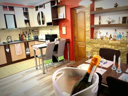 uma cozinha com uma mesa e uma garrafa de vinho em Andreea Residence em Ghimbav