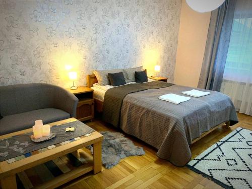 1 dormitorio con 1 cama, 1 silla y 2 lámparas en Andreea Residence en Ghimbav