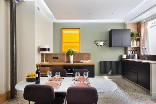 une salle à manger avec une table et des chaises et une cuisine dans l'établissement Boutik Boheme L'Atelier Père Lachaise, à Paris
