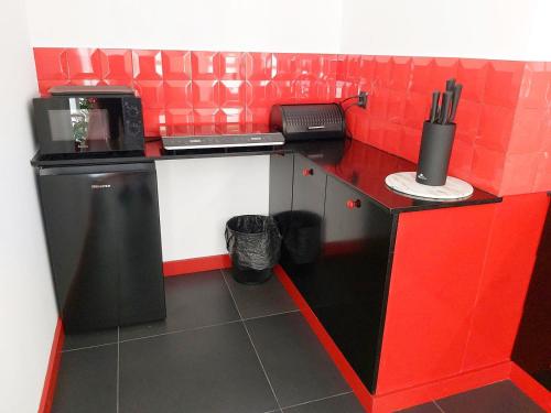 a red and white kitchen with a black counter top at Apartament Parkowa 2 in Morąg