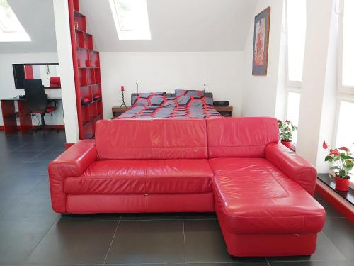 a red leather couch in a living room at Apartament Parkowa 2 in Morąg