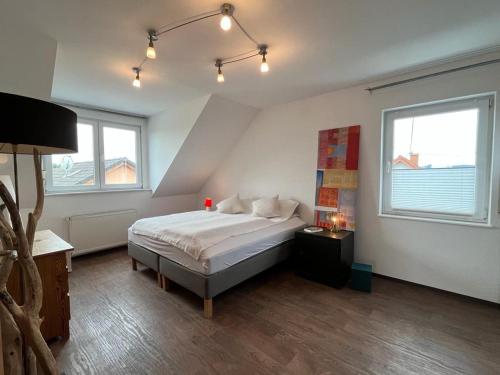 a bedroom with a bed and two windows at Zum schönen Ausblick in Weißenthurm