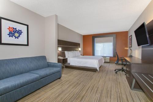 a hotel room with a bed and a couch at Holiday Inn Express Silver Springs - Ocala by IHG in Silver Springs