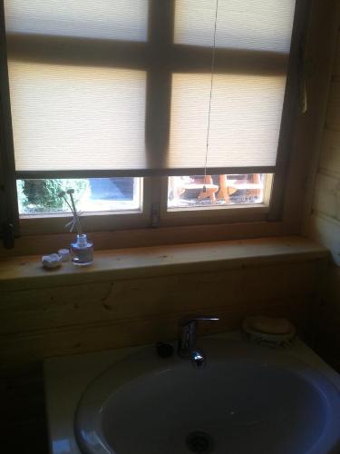 a bathroom with a sink and a window with a windowtaining at Domek in Świnoujście