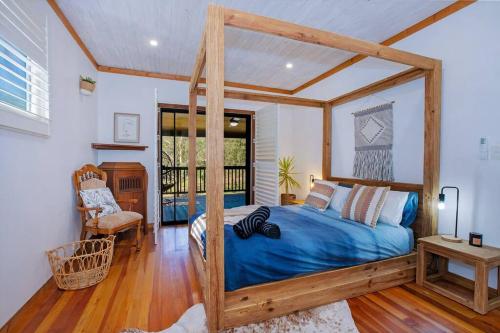 - une chambre avec un lit à baldaquin en bois et des draps bleus dans l'établissement Luxury Farm House on 20 acres - Sleeps 22, à St Albans