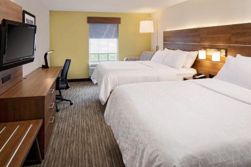 a hotel room with two beds and a flat screen tv at Holiday Inn Express Harrisburg East by IHG in Harrisburg