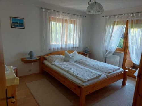 a bedroom with a wooden bed in front of windows at Apartment in Münster/Tirol 450 in Grünsbach