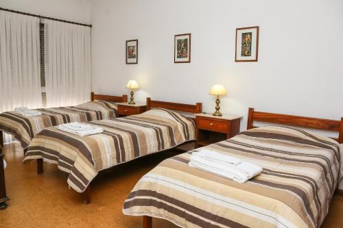 Hotel Oasis في سانتا مارتا دي بيناغياو: ثلاثة أسرة في غرفة الفندق عليها مناشف