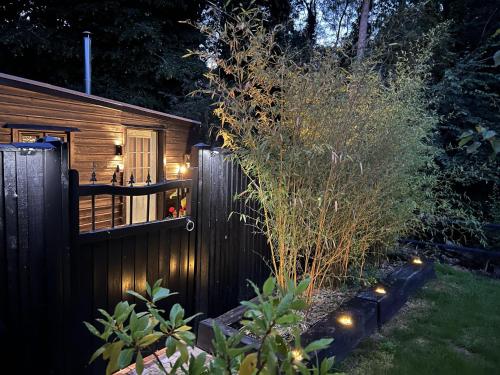 a fence in a yard with lights on it at Charming Woodland Lodge 2 person 1 bedroom in Great Yarmouth