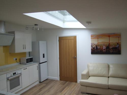 a kitchen with a skylight and a couch in a room at Charming Woodland Lodge 2 person 1 bedroom in Great Yarmouth