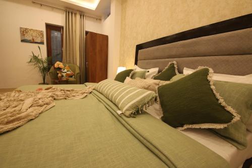 a large bed with green pillows on it at Perfectstayz Value Homes Mussoorie 120 meters uphill in Mussoorie