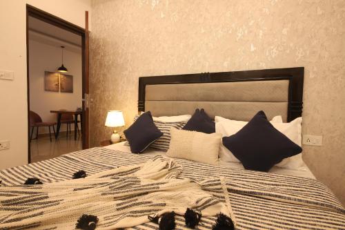 a bedroom with a large bed with black and white pillows at Perfectstayz Value Homes Mussoorie 120 meters uphill in Mussoorie
