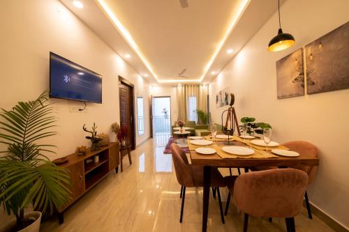 a dining room with a table and a tv at Perfectstayz Value Homes Mussoorie 120 meters uphill in Mussoorie