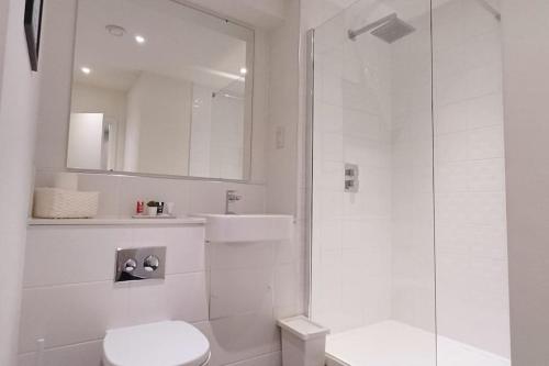 bagno bianco con doccia e servizi igienici di Bright Stylish Apt in Bedford a Bedford