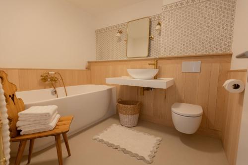 une salle de bain avec une baignoire, un lavabo et des toilettes dans l'établissement Sonnenhof Juliet - design-led Swiss luxury, à Saas-Fee
